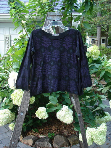 Barclay NWT Batiste Long Sleeved Pullover Fan Floral Black Size 0 displayed on a hanger, showcasing its raw rolled edges, gentle rounded neckline, and detailed floral theme.