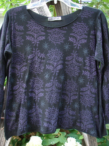 Barclay NWT Batiste Long Sleeved Pullover Fan Floral Black Size 0 displayed on a hanger, showcasing its gentle rounded neckline, raw rolled edgings, and detailed floral theme.