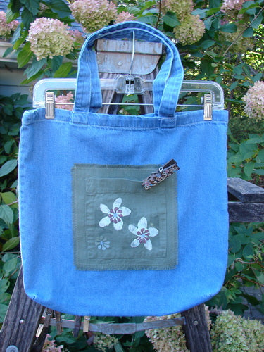 2000 PMU Cotton Tote Bag Summer Floral Pocket Washed Denim One Size featuring colorful floral patches, tote-length shoulder straps, a center front pocket, and a gusset bottom for vintage-inspired style and functionality.