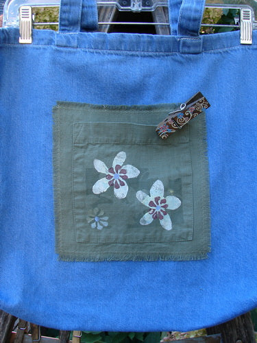 2000 PMU Cotton Tote Bag Summer Floral Pocket Washed Denim One Size features floral patches, tote-length shoulder straps, a center front pocket, and colorful accents, celebrating sustainable vintage design.