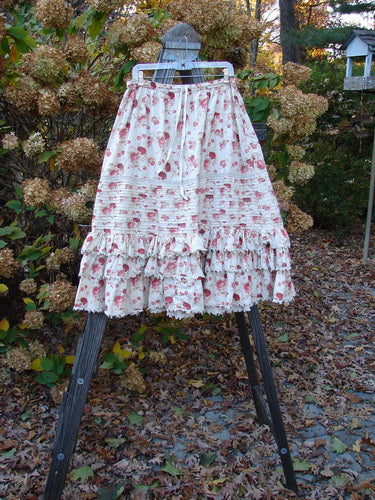 Magnolia Pearl Penelope Skirt Des Rosiers Floral OSFA: A skirt with a drawstring waistline, horizontal pin tuck accents, and lower lacy ruffles.