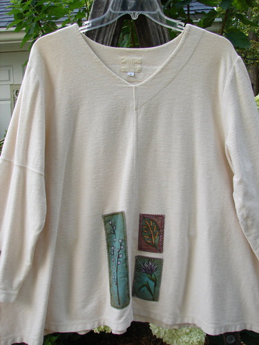 2000 Patched Resort Sweatshirt Nature Dove Size 2, featuring nature-themed painted patches, billowy A-line swing, vented sides, drop shoulders, and a double-paneled V neckline, hanging on a clothes hanger.