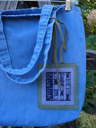 2000 PMU Cotton Tote Bag Summer Floral Pocket Washed Denim One Size, featuring vibrant summer floral patches, tote-length straps, and a center front pocket, highlighting Bluefishfinder.com's commitment to sustainable upcycled vintage designs.