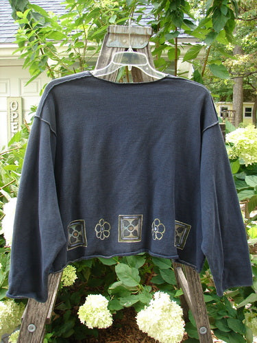 1997 Fleece Long Sleeved Boxy Top Mosaic Flower Ebony Size 2 displayed on a swinger, showcasing wide shape, drop shoulders, mosaic flower hem, and exterior whip stitching.