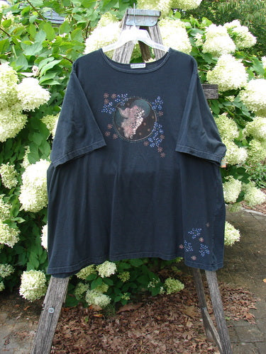 Barclay Short Sleeved Studio Tee Magic Moon Cloud Black Size 3 in black, a loose short-sleeved tee with a centered moon-and-cloud graphic and small floral accents. The soft cotton shirt hangs on a wooden ladder, with a muted, matte finish.