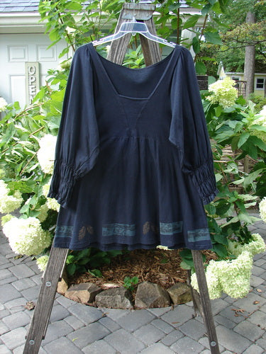 1993 Juliet Dress Leaf and Vine Black Size 1 displayed on a wooden rack, highlighting its Renaissance-style wide sleeves, deeper V-neckline, and intricate leaf and vine pattern.