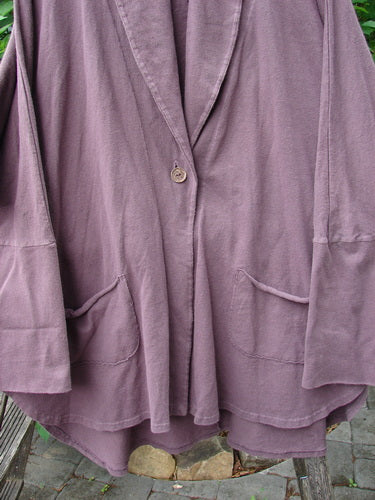 Barclay Reprocessed Golden Hour Deco Jacket Rear Parrot Plum Wine OSFA, featuring drop dolman shoulders, long sleeves, and oversized pockets, displayed on a wooden fence, highlighting its unique texture and design.
