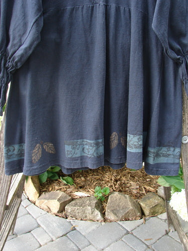 1993 Juliet Dress Leaf and Vine Black Size 1: Blue vintage peasant dress with V neckline, empire waist, smocked lower sleeves, wider upper sleeves, A-line shape, double rear pleats, and detailed leaf and vine pattern.