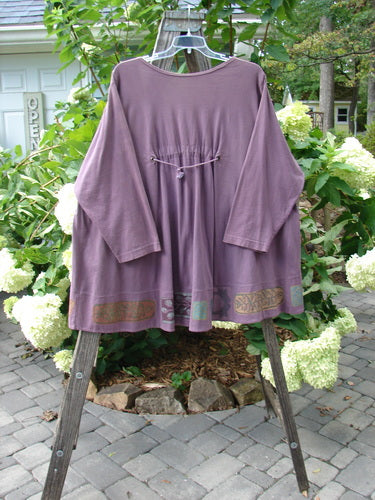 1993 Modernismo Pullover Cardigan Nature Plum Wine Altered Size 2 displayed on a wooden rack, showcasing its A-line swing, old-time buttons, kangaroo pockets, and signature patch.