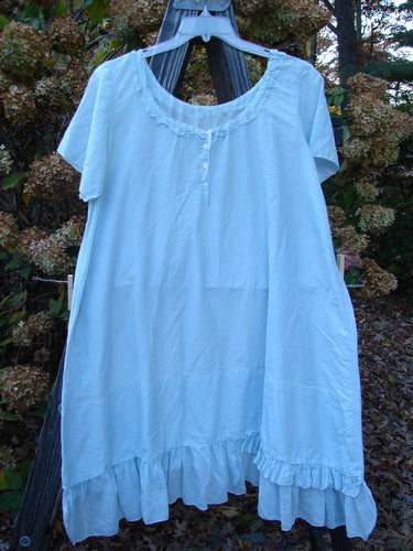 Magnolia Pearl Voile Tie Neck Peasant Tunic, blue dress on clothes line, cotton fabric, adjustable ribbon tie neckline, short sleeves, ruffled hem with fluttery edge, love theme patch.