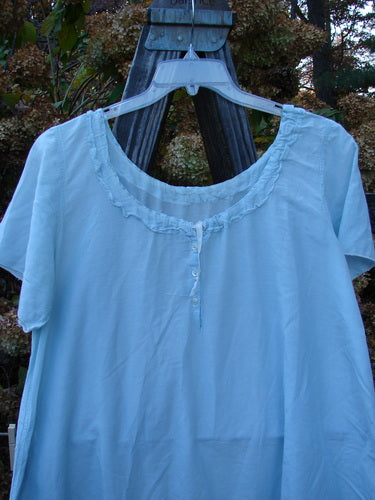 Magnolia Pearl Voile Tie Neck Peasant Tunic - Blue shirt on a swinger with ribbon tie neckline, short sleeves, and ruffled lower hem.