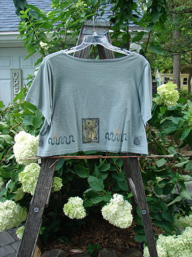 1993 Travel Top Many Moons Ocean Size 2 displayed on an outdoor swing, showcasing its scooped neckline, cropped shape, unique wooden buttons, and signature Blue Fish patch on the back center shoulder.