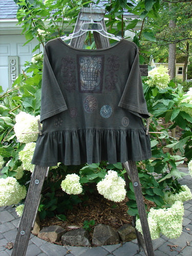 1992 Holiday Short Sleeved Peplum Top Black Sand Size 1 displayed on a clothes rack. The top features a thin ribbed neckline, drop shoulders, and a peplum lower, in perfect condition.