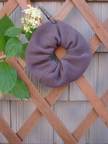 2000 PMU Thermal Hair Scrunchie Unpainted Brum One Size, displayed on a wooden lattice, showcasing its ruffled fabric and soft texture, highlighting its vintage-inspired design from Bluefishfinder.com’s sustainable collection.