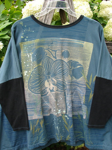 Barclay Cotton Lycra Rib Sleeved Treesoul Pullover in Orchid Forest OSFA, a blue-green long-sleeve top with black ribbed sleeves and collar. The front shows a large orchid graphic with layered painterly stripes, leafy accents, and a soft textured finish.