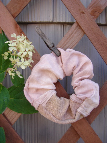 Barclay PMU Linen Hair Scrunchie Unpainted Textured Mauve One Size, featuring a ruffled fabric and thin elastic band, displayed on a wooden pole with floral accents, embodying Bluefishfinder.com's sustainable vintage style.