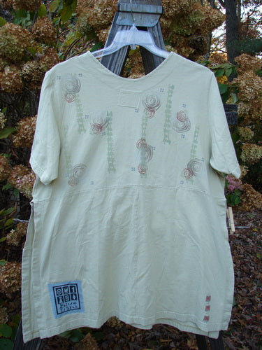 A white shirt with a unique design, short sleeves, and tall side vents. Features two drop exterior pockets and a celebrate theme paint. Size 0.