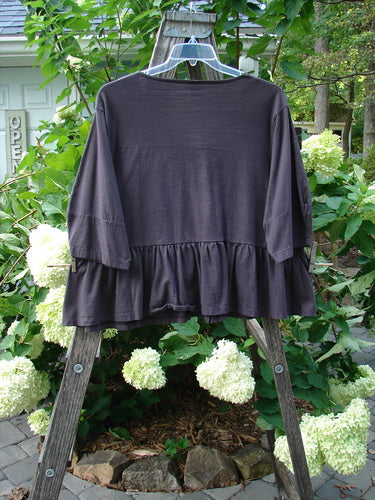 Barclay Peplum Pocket Jacket Compass Brum Size 2 displayed on a wooden rack, showcasing its boxy crop shape and three-quarter sleeves with a continuous painted peplum design.