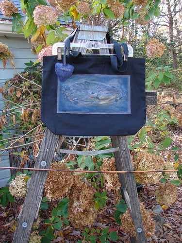 1998 PMU Patched Tote Bag Sling Sun & Wind Black One Size displayed on a wooden ladder, featuring a fish patch and long shoulder straps, highlighting Bluefishfinder.com's focus on vintage, sustainable design.