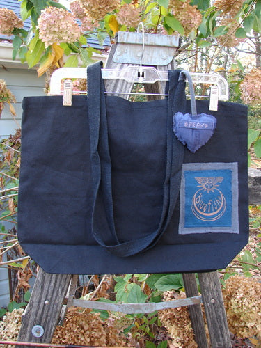 1998 PMU Patched Tote Bag Sling Sun & Wind Black One Size displayed on a rack, featuring extra-long shoulder straps, a generous top opening, a gusset bottom, and a colorful puffy heart accent.