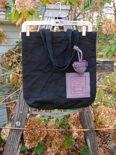 1994 PMU Patched Tote Bag Forest Walk Black One Size displayed on a wooden ladder, featuring extra-long shoulder straps and a colorful puffy heart accent, highlighting its sustainable vintage design.