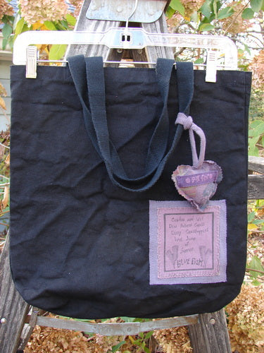 1994 PMU Patched Tote Bag Forest Walk Black One Size features a black canvas with a purple heart patch, extra-long shoulder straps, and a generous top opening, celebrating sustainable vintage design.