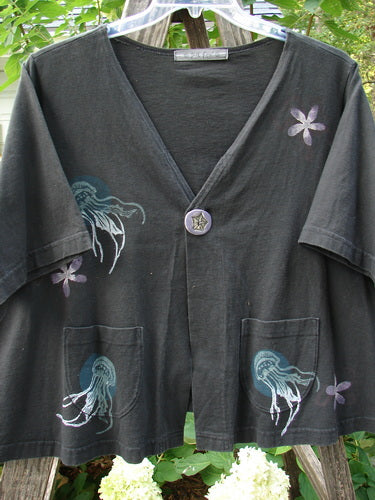 1997 Cove Jacket Sea Life Ebony Size 2, featuring a black shirt with a blue and white jellyfish design, a V-shaped neckline, and a unique porcelain closure with sea life motif.