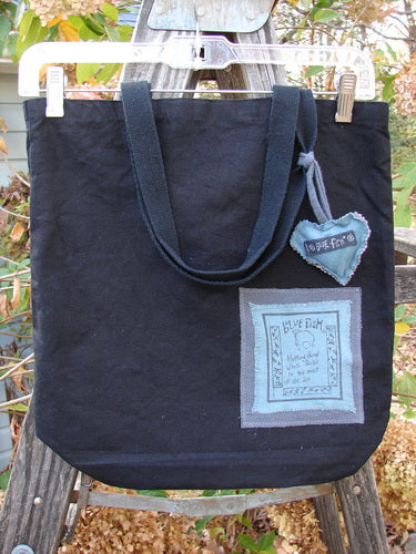 1994 PMU Patched Tote Bag Wood Path Black One Size featuring a colorful puffy heart patch and long shoulder straps, crafted from heavyweight black canvas celebrating sustainable vintage designs by Bluefishfinder.com.