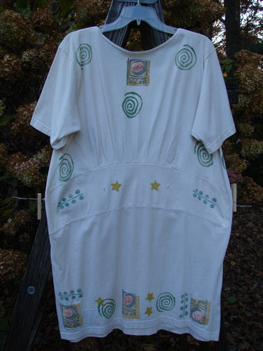 1992 Little Storma Dress Moon White OSFA: A white dress with green designs, a deep rounded neckline, and a downward curved front waist seam. It features super gathered top half rear with rear optional ribbon slits and celestial moon theme patches. Bust 42, Waist 42, Hips 44, Sweep 46, Length 36.