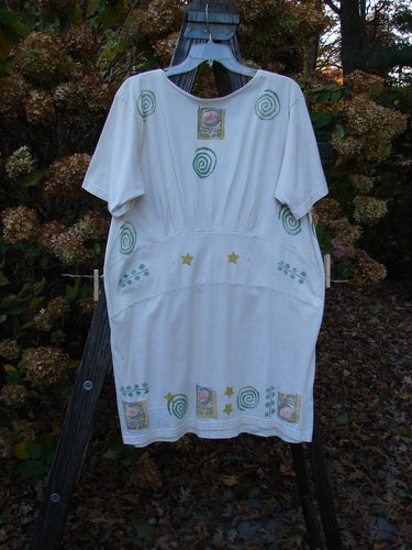 1992 Little Storma Dress Moon White OSFA: A white dress with green designs, featuring a deep rounded neckline, tapering lower, and rear optional ribbon slits. Made from mid-weight cotton, this vintage piece is a true find. Bust 42, Waist 42, Hips 44, Sweep 46, Length 36.