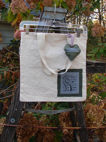 2000 PMU Patched Organic Cotton Canvas Pocket Tote Bag Frayed Floral Natural One Size, featuring a heart charm and floral patches, displayed on a wooden ladder with plant accents, embodying Bluefishfinder.com's vintage sustainability ethos.