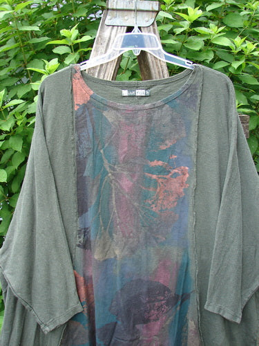 Barclay Cotton Hemp Exterior Stitch Hi Low Tunic Metallic Floral Green Stick OSFA features a wide, rounded neckline, dolman sleeves, and curvy stitch details, highlighting its unique high-low hemline and metallic floral accents.