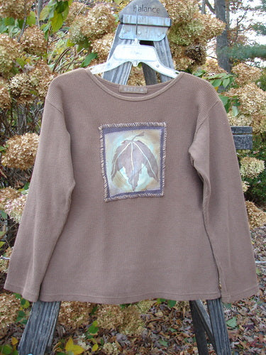 1997 PMU Patched Thermal Long Sleeved Top Leaf Mandorla Size 1: A brown sweater with a leaf patch, perfect for layering.