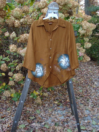 A brown shirt with blue flowers on a rack, part of the Barclay Viscose Lilac Scallop Jacket Copper Fallen Leaf Altered Size 0 collection.