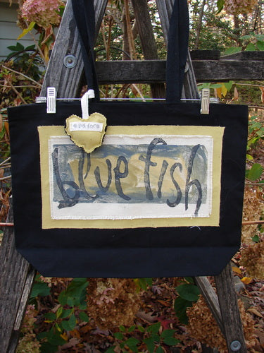 1995 PMU Patched Tote Bag on a wooden ladder, featuring a colorful puffy heart accent and signature patch, highlighting Bluefishfinder.com's vintage style and sustainable design ethos.