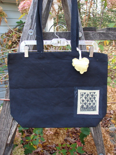 1995 PMU Patched Tote Bag Sling Vintage Logo Frayed Black Yellow One Size, featuring a yellow heart patch on heavy black canvas, with long shoulder straps and generous top opening.