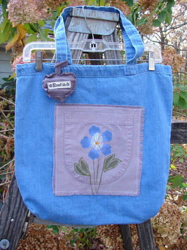 2000 PMU Patched Cotton Pocket Tote Bag Frayed Daisy Washed Denim One Size, featuring a floral patch, puffy heart charm, and signature Blue Fish patch, celebrating sustainable vintage design from Bluefishfinder.com.