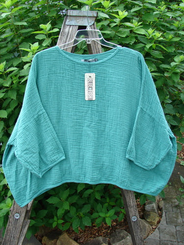 Barclay NWT Gauze Square Mariposa Pullover Unpainted Jade OSFA displayed outdoors on a hanger, highlighting its lightweight, textured cotton gauze fabric, three-quarter sleeves, and flowy, boxy shape, perfect for layering.