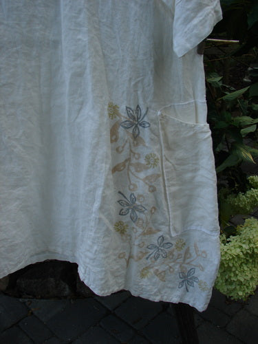 Barclay Linen Cross Over Urchin Tunic Dress Daisy Cloud Size 2 featuring a crossover V neckline, drop shoulders, and double side pockets, displayed in a close-up shot highlighting the delicate daisy pattern.