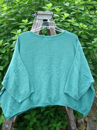 Barclay NWT Gauze Square Mariposa Pullover Unpainted Jade OSFA displayed on a hanger, features a textured lightweight cotton gauze, rounded neckline, three-quarter wide sleeves, and a boxy, flowy shape.