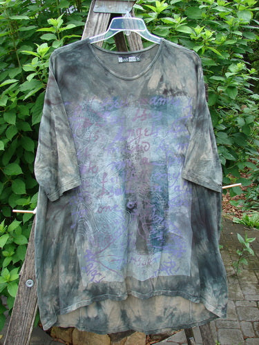 Barclay Tournesol Tunic Wind Script Mottled Green Earth OSFA displayed on a pole, featuring a loose fit with drop shoulders, three-quarter sleeves, and varying hemline, embodying vintage Blue Fish Clothing creativity.
