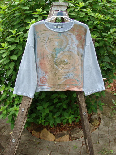 Barclay Fleece Crop Boxy Sweatshirt with Blue Fish Land theme art, displayed on a wooden ladder, showcasing its wide, drop-shoulder design and cozy fleece fabric, embodying Bluefishfinder.com's vintage aesthetic.