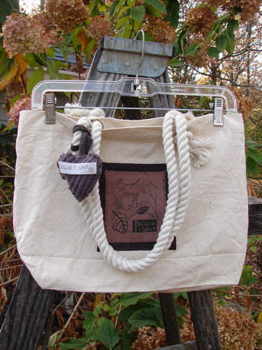 1998 PMU Patched Canvas Rope Pocket Tote Bag Ash Leaf Natural One Size on a wooden fence, showcasing its cotton rope straps, interior snap, gusset bottom, and Blue Fish patch.