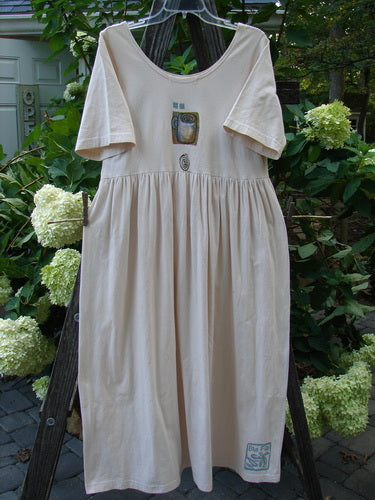 1996 Simple Dress Magic Teacup Birch Bark Size 0: Short-sleeved, organic cotton dress with a deeper rounded neckline, drop empire waist, and full sweeping skirt, displayed on a clothesline outdoors.