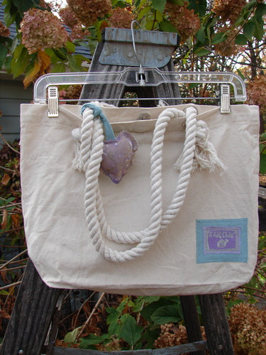 Barclay PMU Patched Canvas Rope Pocket Tote Bag Butterfly Natural One Size hanging outdoors, featuring a cotton rope handle, puffy heart detail, and signature Blue Fish patch celebrating sustainable vintage design.