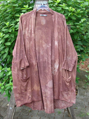 Barclay Bamboo Dolman Day Jacket Unpainted Mottled Autumn Copper OSFA, displayed on a rack, features an open front, dolman sleeves, and a varying hemline, exemplifying BlueFishFinder's unique vintage clothing style.