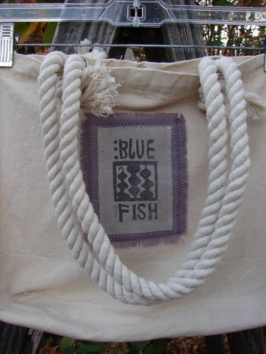 2000 PMU Patched Canvas Rope Pocket Tote Bag Daisy Natural One Size featuring a sturdy cotton rope handle, exterior front pocket patch, and signature Blue Fish patch, celebrating sustainable creativity from Bluefishfinder.com.