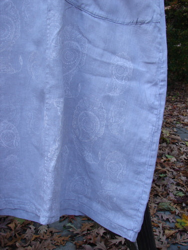 Barclay Linen Cotton Sleeve Urchin Dress Paisley Lavender Cloud Size 1 - Close-up of a pleated white cloth dress with curly three-quarter sleeves and a widening piped hemline.