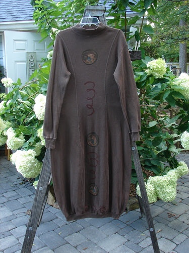 1996 Thermal Day Dress Celestial Molasses Size 0 displayed on a wooden stand, showcasing its hourglass shape, thick ribbed cuffs, and unique ribbed hemline with celestial-themed paint accents.