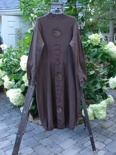 1996 Thermal Day Dress Celestial Molasses Size 0 displayed on a wooden rack, showcasing a figure-eight shape, thick ribbed cuffs, and a unique ribbed hemline, emphasizing its hourglass silhouette.